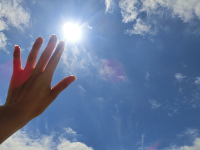 手と太陽と空